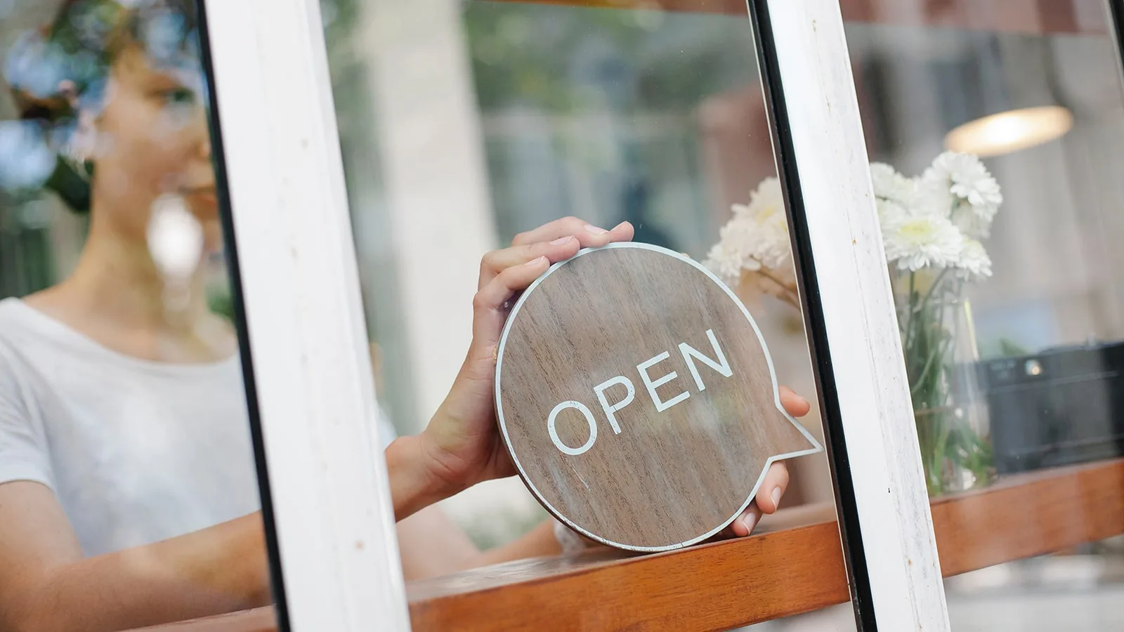 Host changing the sign at a restaurant from close to open