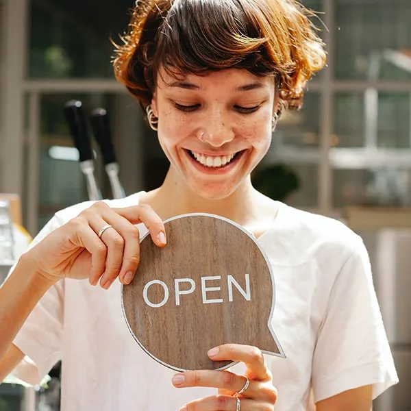 Host changing the sign at a restaurant from close to open for reservation