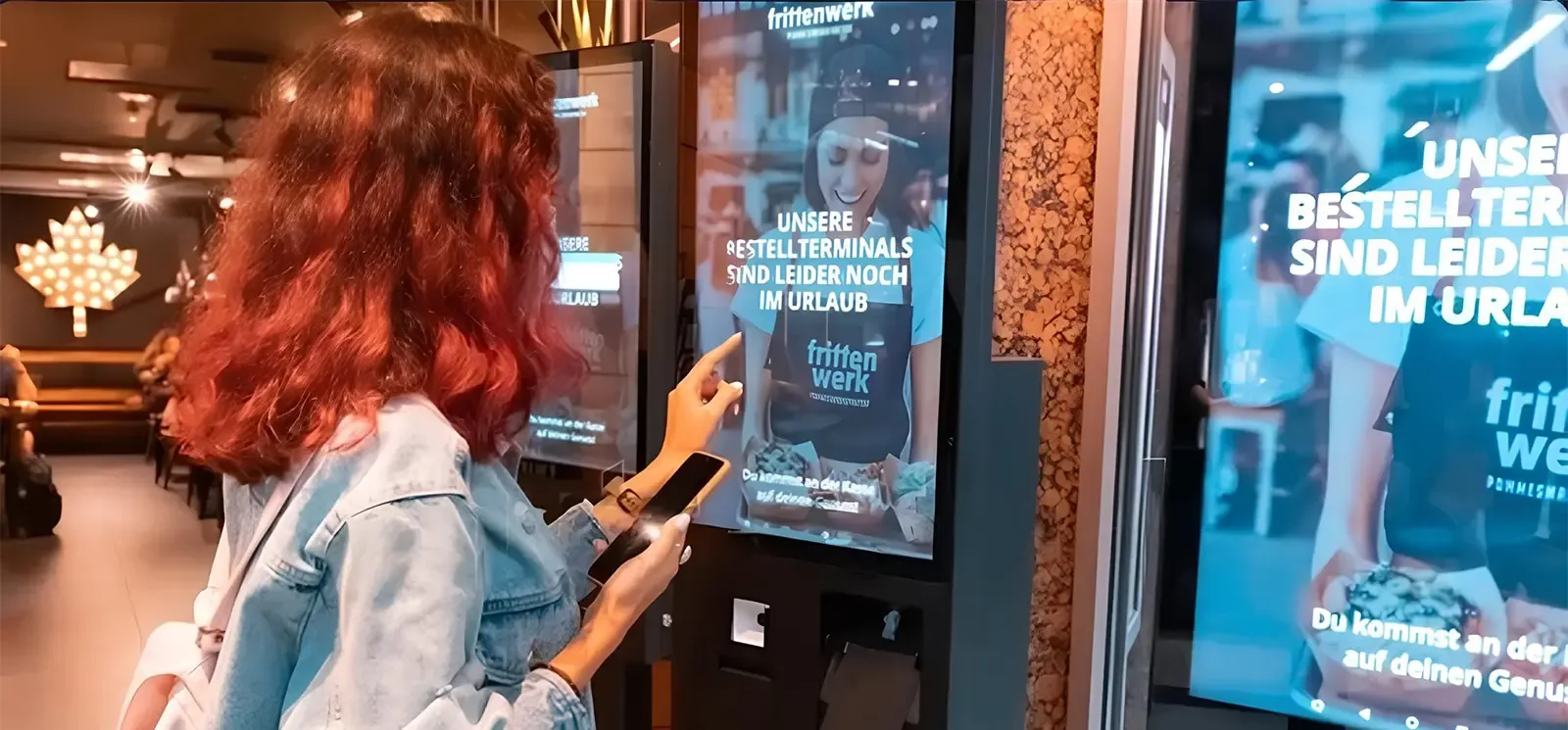 Woman adding her name to a restaurant waitlist from a self-service kiosk